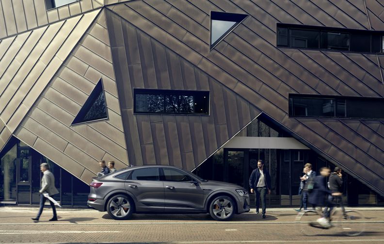 Fußgänger um einen grauen Audi