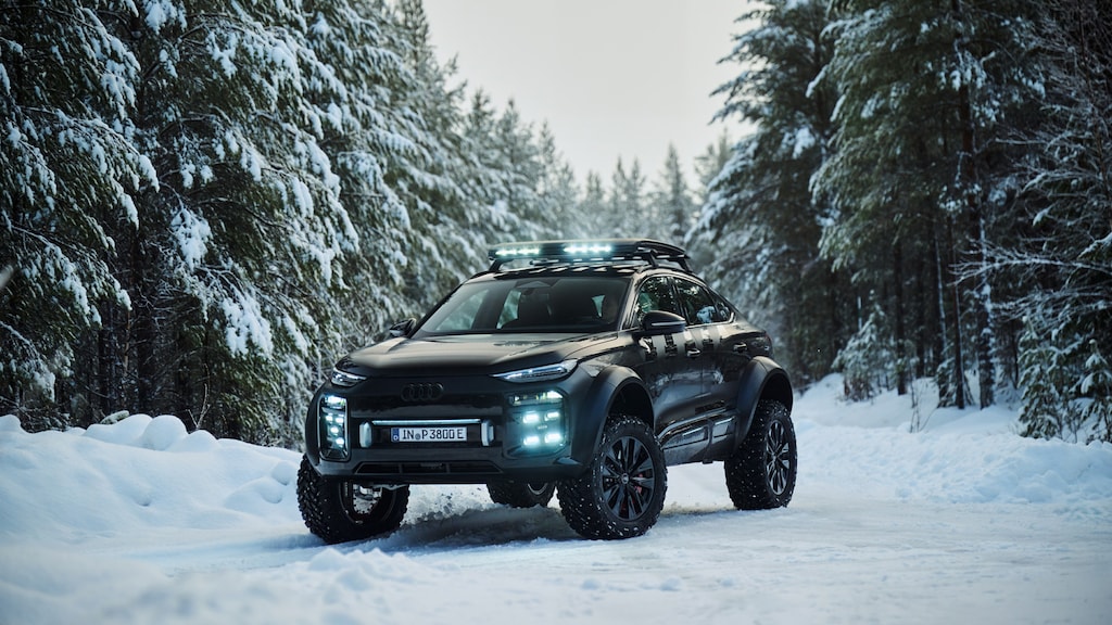 Photo of an Audi Q6 e-tron offroad concept in Mythos Black Metallic between snow-covered fir trees