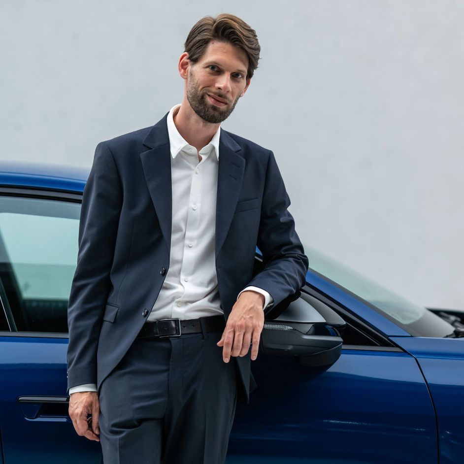Jakob Hirzel stands in front of a blue-painted Audi A5