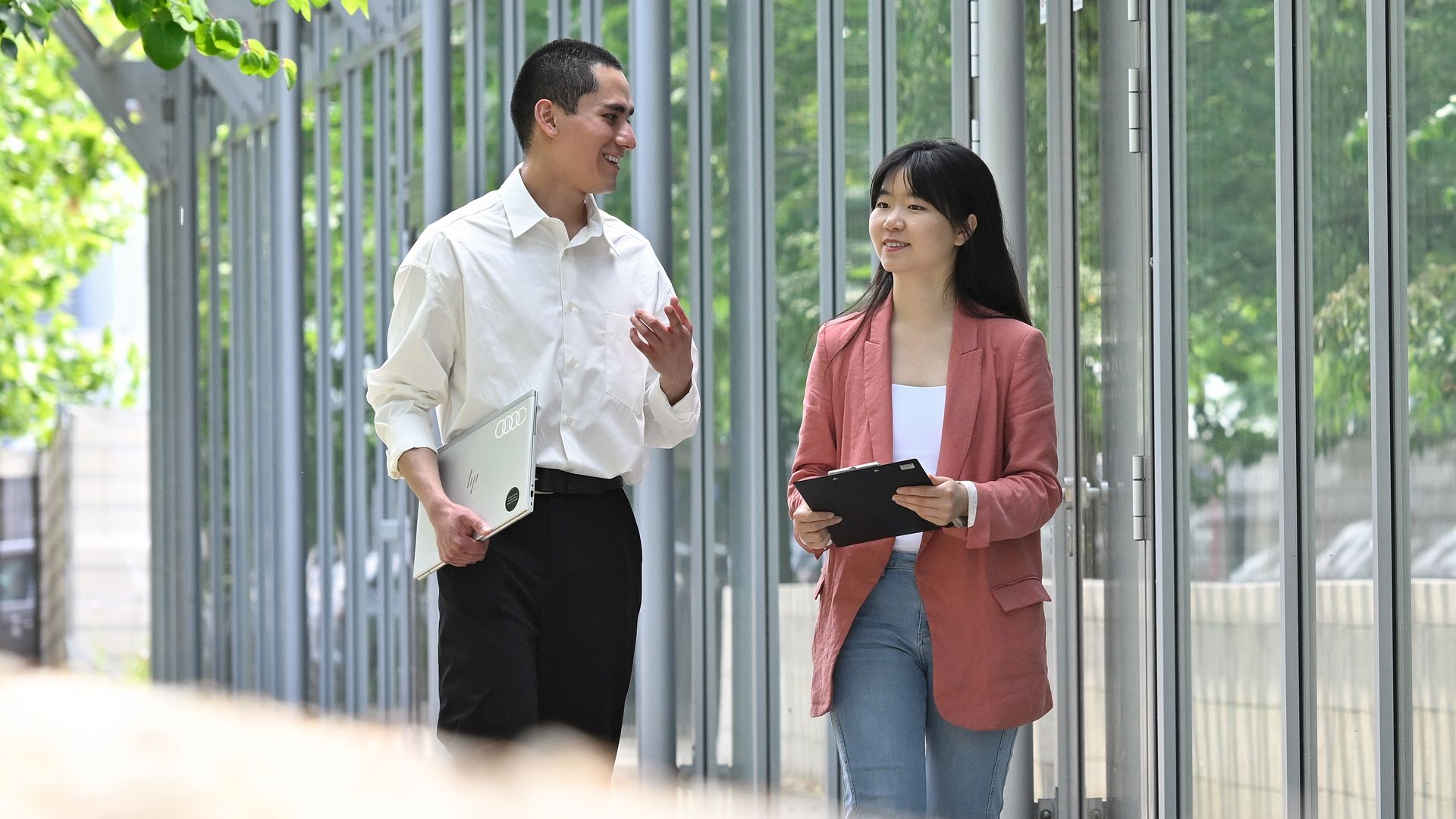 Two students are talking to each other and walking outside