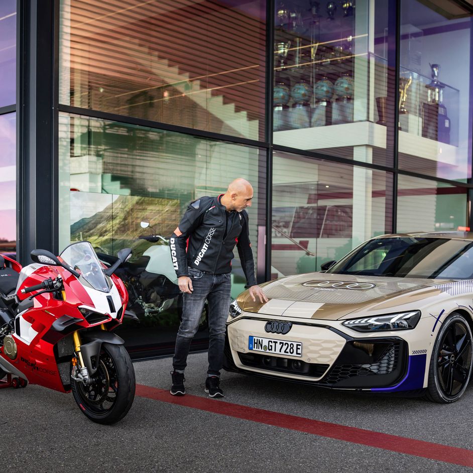 Ducati-Testchef Alessandro Valia streicht über die Motorhaube des Audi e-tron GT