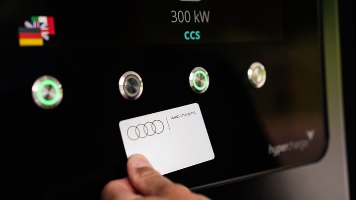 Eine Hand hält eine Audi Charging Karte an die NFC-Fläche beim Charging hub