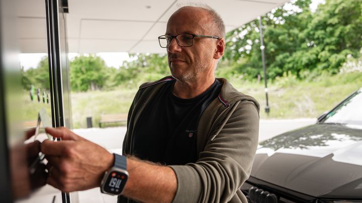 Ein Mann hält eine Karte an die die NFC-Fläche des Audi charging hubs