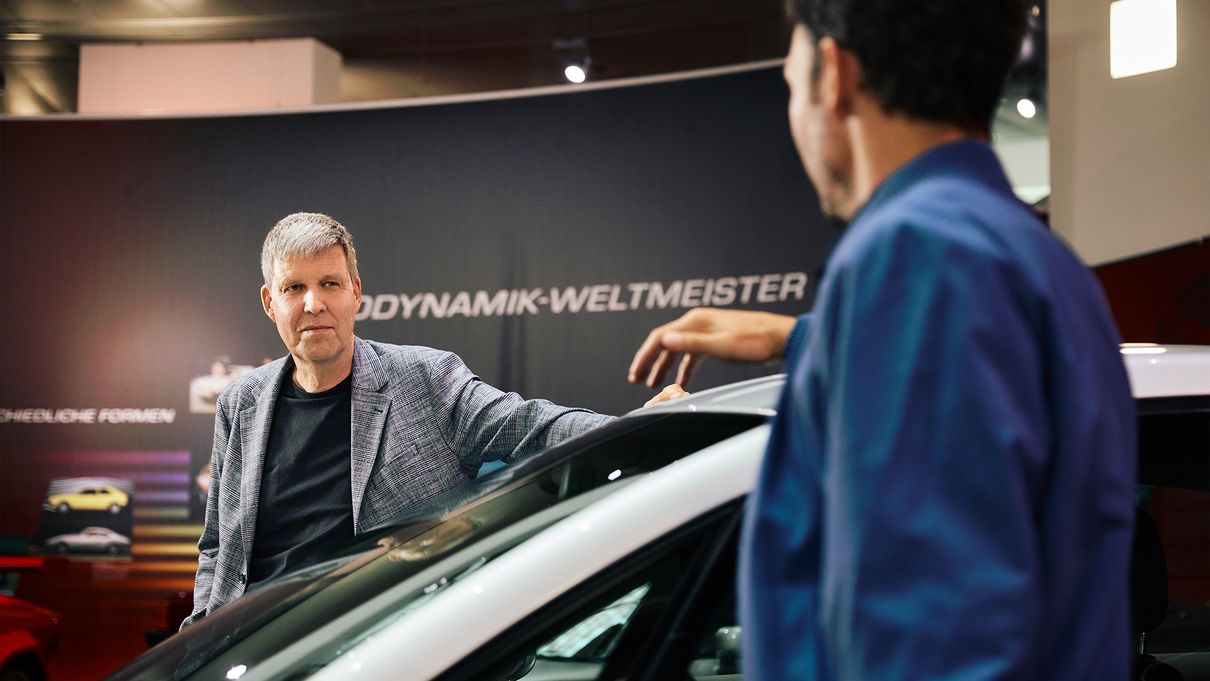 Rüdiger Recknagel and Felix Neureuther look at each other over the roof of an Audi model