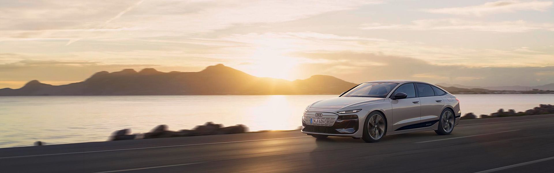 Audi A6 Sportback e-tron performance fährt vor einem Sonnenuntergang